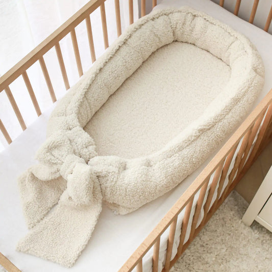 Håndlaget babynest med sløyfe