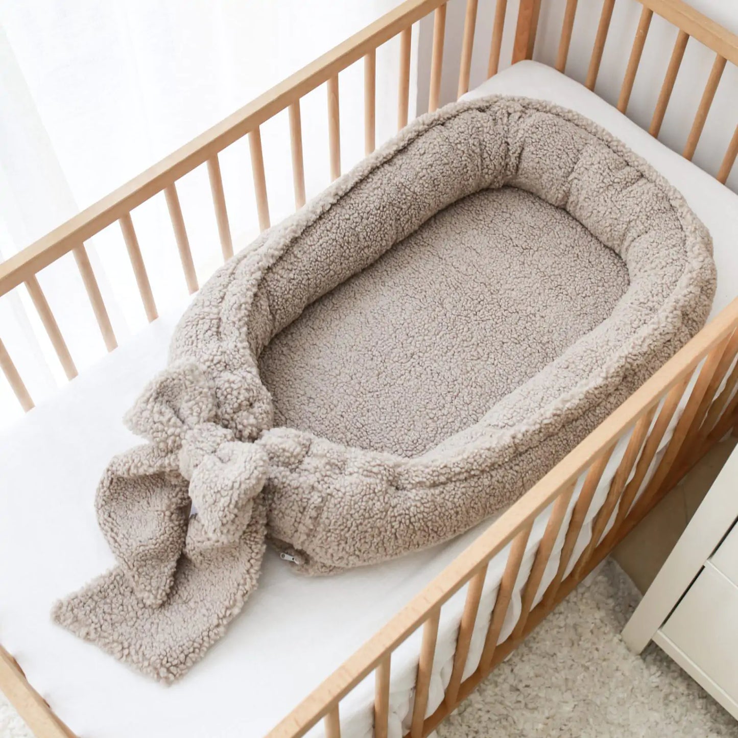 Håndlaget babynest med sløyfe