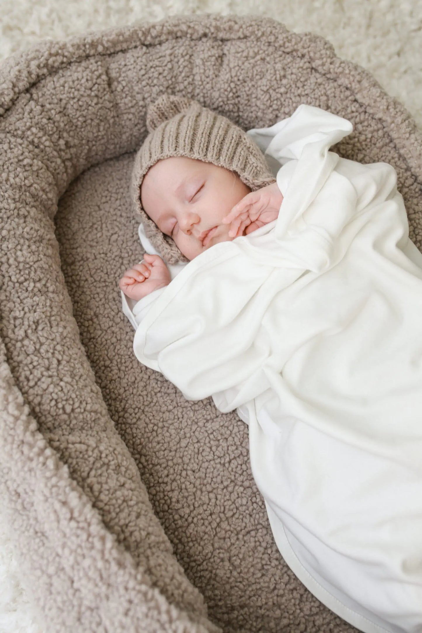 Håndlaget babynest med sløyfe